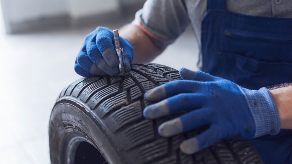 wheel alignment services, hands checking tyre tread depth and wear